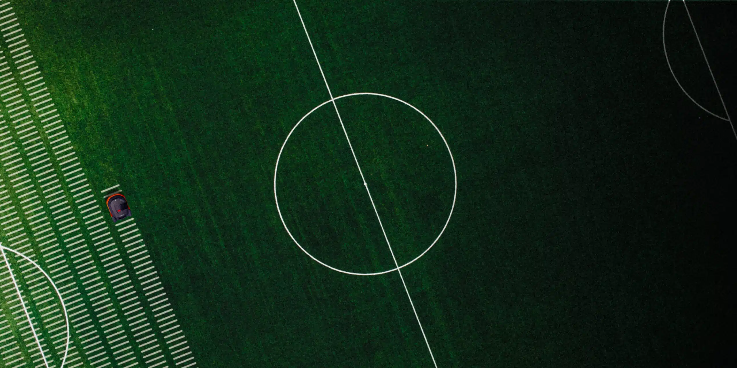 Drohnenaufnahme: Segway Navimow Mähroboter mäht präzise Linien auf einem Fußballplatz – perfekt für große Sportflächen mit exakter Rasenpflege